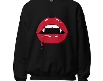 May include: A black long-sleeve crewneck sweatshirt featuring a graphic print of bright red lips with white vampire fangs. A single drop of red liquid drips from the lower lip. The design is centered on the chest of the garment.