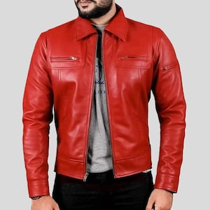 May include: A vibrant red leather jacket featuring a classic collar, a full-length front zipper, and two horizontal zippered chest pockets. The jacket has long sleeves with buttoned cuffs and is worn over a grey t-shirt and dark trousers.