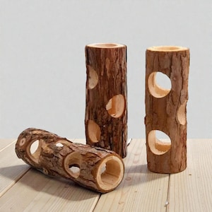 Op de afbeelding: Drie cilindervormige houten stammen met een ruwe, getextureerde schors aan de buitenkant. Elke stam heeft meerdere ronde uitsparingen of gaten over de lengte, waardoor het gladde, lichtgekleurde houtnerf in de uitgeholde centra zichtbaar is.