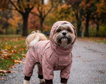 Könnte beinhalten: Ein kleiner Hund mit langem Fell trägt einen altrosa Regenmantel mit Kapuze und dunkelbraunen Rippbündchen. Die Jacke hat eine Kapuze mit verstellbaren Kordelzügen, eine kleine Tasche auf dem Rücken und den Aufdruck OUTDOOR an der Seite.