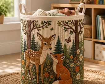 May include: A cylindrical fabric storage basket with two top handles, featuring a quilted exterior decorated with an embroidered forest scene. The design includes a brown deer and an orange fox surrounded by green pine trees and colorful flowers.