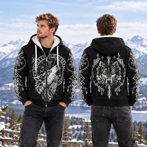 May include: A black zip-up hoodie with a white sherpa lining, featuring a graphic of a howling wolf on the front and a wolf face on the back, both surrounded by intricate white geometric patterns and runic symbols on a dark background.