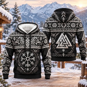 May include: A black hooded sweatshirt with a white sherpa lining, featuring a front graphic of a Vegvisir compass and wolf heads, and a back graphic of a Valknut symbol, all surrounded by intricate white geometric and snowflake patterns.