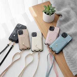May include: Five smartphone cases with textured surfaces and attached card wallets featuring snap closures. Each case includes a matching detachable crossbody strap with gold-toned hardware. The cases are available in black, beige, cream, pink, and light blue.