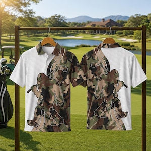 May include: A short-sleeve polo shirt featuring a camouflage pattern with a white section on the left side. The design includes a graphic of a large creature resembling Bigfoot holding a golf club, depicted in a dark silhouette outline.