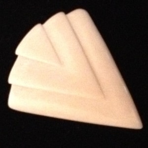 Op de afbeelding: Een witte, driehoekige broche met een geometrisch ontwerp. De broche heeft drie lagen overlappende driehoeken, waardoor een gelaagd effect ontstaat.