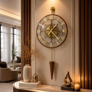 Puede incluir: Un reloj de pared redondo con marco de madera oscura, números romanos dorados y un diseño de brújula central con manecillas doradas. Una varilla dorada cuelga del reloj, terminando en un peso de péndulo puntiagudo de madera oscura.