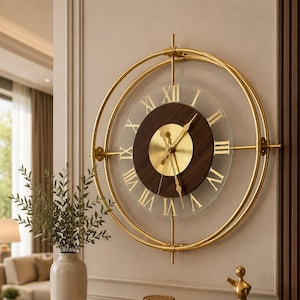 May include: A circular wall clock featuring a gold metal frame, a transparent glass face, and a dark brown wooden centre. The clock displays gold Roman numerals and gold hands, with a central gold circular plate housing the clock mechanism.