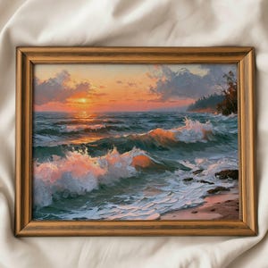 Pode incluir: Uma pintura de paisagem emoldurada retratando um pôr do sol sobre o oceano com ondas quebrando em tons de azul-petróleo, laranja e rosa. A cena apresenta uma costa rochosa com árvores no lado direito e um sol dourado baixo no horizonte.