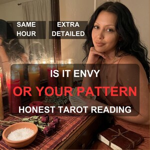 May include: A person holding a deck of tarot cards in front of a mirror with several tall pillar candles in red, yellow, and orange hues. Text on the image reads: SAME HOUR, EXTRA DETAILED, IS IT ENVY OR YOUR PATTERN, HONEST TAROT READING.