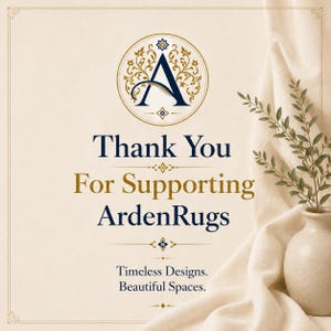 Op de afbeelding: Een cr&egrave;mekleurige kaart met een donkerblauw logo met een gestileerde letter A in een gouden cirkelvormig frame. De tekst luidt Thank You For Supporting ArdenRugs en Timeless Designs. Beautiful Spaces. Een beige vaas met groene bladeren staat ernaast.