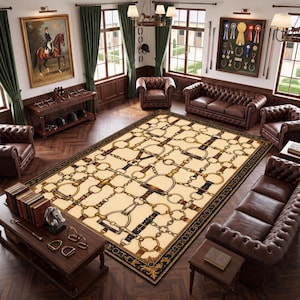 May include: A large rectangular area rug featuring a cream-coloured field with a repeating pattern of brown leather straps, gold-toned metal buckles, and equestrian bit hardware, framed by a wide black border with ornate gold scrollwork details.