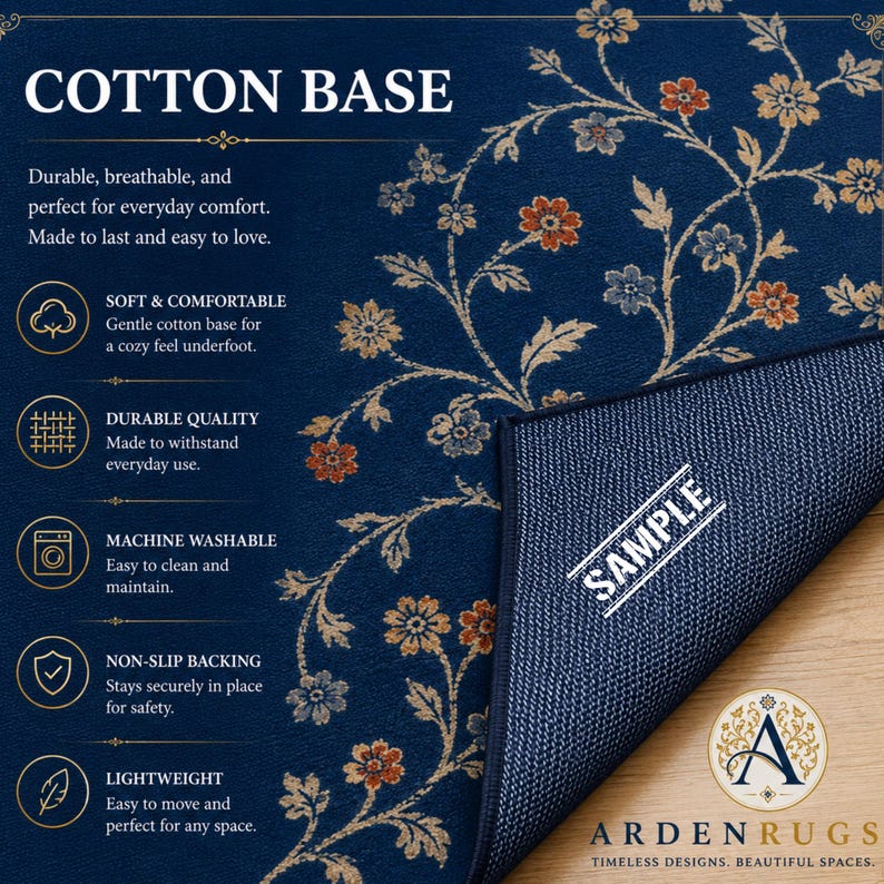 Op de afbeelding: Een donkerblauw vloerkleed met een bloemenpatroon in oranje, beige en lichtblauw. Het kleed bevat tekst waaronder COTTON BASE, SOFT & COMFORTABLE, DURABLE QUALITY, MACHINE WASHABLE, NON-SLIP BACKING, LIGHTWEIGHT, SAMPLE en ARDEN RUGS.