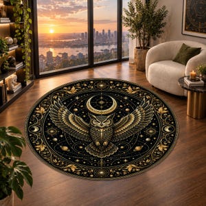 May include: A circular area rug featuring a black background with a central golden owl illustration with wings spread wide. The design includes a crescent moon, celestial stars, planetary spheres, and intricate floral borders in gold ink.