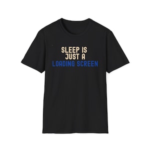 以下が含まれることがあります： 胸元に「SLEEP IS JUST A LOADING SCREEN」というテキストがプリントされた黒の半袖Tシャツです。「SLEEP IS JUST A」の文字は明るいベージュ色で、「LOADING SCREEN」の文字は鮮やかな青色でデザインされています。