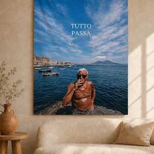 May include: A rectangular wall tapestry featuring a photographic print of a shirtless person wearing sunglasses, smoking, and standing by the sea. The text TUTTO PASSA is printed in white in the sky and on the person's chest, with boats and a mountain visible.