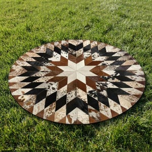 Könnte beinhalten: Ein runder Teppich mit einem geometrischen Sternmuster aus zusammengenähten Kuhfell-Paneelen. Das Design umfasst eine Palette aus schwarzen, weißen, braunen und gesprenkelten Felltexturen, die in einem Rauten- und Dreiecksmuster angeordnet sind.