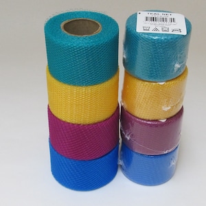May include: A stack of four rolls of teal, yellow, burgundy, and blue mesh ribbon. The teal roll has a label that reads "Teal Net 2.5" x 10 yds.  The label also has care instructions.