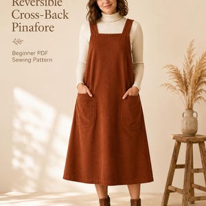 Op de afbeelding: Een roestkleurige corduroy pinafore-jurk met een vierkante halslijn, brede schouderbanden en twee grote opgestikte zakken aan de voorzijde. De tekst op de afbeelding luidt: Reversible Cross-Back Pinafore, Beginner PDF Sewing Pattern.