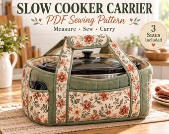 May include: A quilted fabric slow cooker carrier featuring a floral pattern with red and orange flowers on a cream background, accented by sage green panels. The carrier includes sturdy handles, exterior pockets, and a black slow cooker inside.