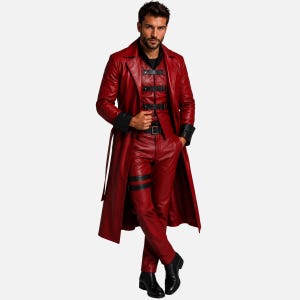 Op de afbeelding: Een lange rode leren trenchcoat gedragen over een bijpassend rood leren vest en broek. Het vest heeft zwarte horizontale banden met gespen. De jas heeft zwarte manchetten en de broek bevat zwarte beenbanden. Zwarte leren laarzen maken de set compleet.
