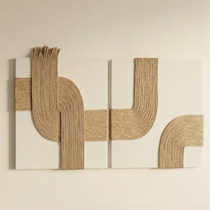 Op de afbeelding: Een diptiek wandkunstset bestaande uit twee witte rechthoekige doeken. Elk doek is versierd met dik, beige jutekoord dat in gebogen, elkaar kruisende lijnen is gerangschikt, wat een gestructureerd en driedimensionaal patroon creëert.