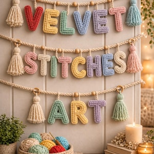 以下が含まれることがあります： VELVET STITCHES ARTという文字を綴った、パステルカラーと原色の編み込み文字が特徴の3段式壁掛け装飾。文字は木製のビーズが付いた太いロープから吊り下げられており、各ロープの端には装飾的なタッセルがあしらわれています。
