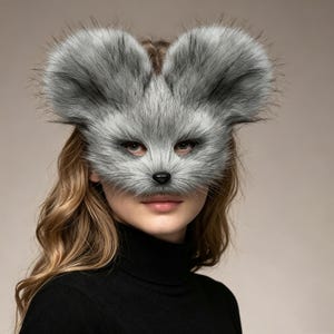 May include: A gray faux fur animal mask featuring large rounded ears, a pointed snout, and a small black nose. The mask covers the upper portion of the face, including the eyes, and is crafted from textured, realistic-looking synthetic gray fur.