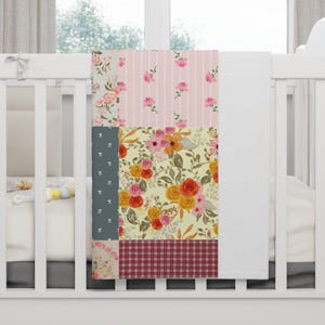 May include: A rectangular blanket featuring a patchwork design with various patterns including floral prints in yellow, orange, and pink, a pink and white striped section with small flowers, a dark gray panel with white dots, and a red plaid section.