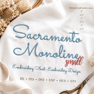 Op de afbeelding: Witte stof met blauw en rood machinaal borduurwerk met de tekst Sacramento Monoline small, Embroidery Font, Embroidery Design. De tekst vermeldt bestandsformaten BX, PES, DST, EXP, HUS, VP3 en borduurmaten van 2,54 tot 8,89 cm.