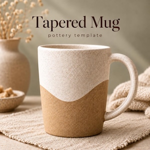 Könnte beinhalten: Ein konischer Becher im zweifarbigen Design mit einem gesprenkelten cremefarbenen oberen Teil und einem einfarbigen beigen unteren Teil. Der Text Tapered Mug pottery template steht über dem Becher. Er hat einen geschwungenen Henkel und eine glatte, matte Oberfläche.