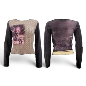 Könnte beinhalten: Ein Langarmshirt mit beigefarbenem, strukturiertem Vorderteil, das einen rechteckigen Grafikdruck einer Person mit einem Karren zeigt, kombiniert mit dunklen Rippärmeln. Das Rückenteil weist einen dunklen, abstrakten Grafikdruck auf.
