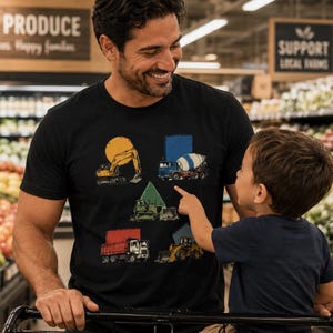 May include: A black short-sleeved t-shirt featuring a graphic print of five construction vehicles, including an excavator, a cement mixer, a bulldozer, a dump truck, and a front loader, each positioned within or near a distinct geometric shape.