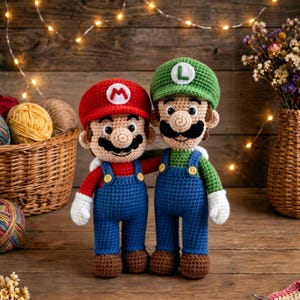 Puede incluir: Dos muñecos tejidos a mano en ganchillo que representan a Mario y Luigi. Mario lleva una gorra roja con una M, una camiseta roja y un peto azul. Luigi lleva una gorra verde con una L, una camiseta verde y un peto azul. Guantes blancos y zapatos marrones.