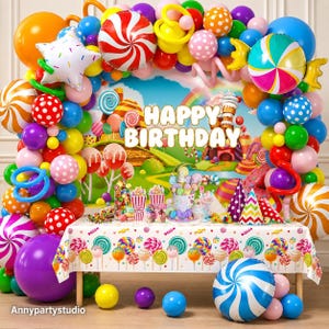May include: A candy-themed party decoration set featuring a colorful balloon arch with red, white, and blue swirl balloons, a Happy Birthday backdrop, and a table covered in a patterned tablecloth with candy graphics and various party supplies.