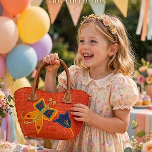 May include: An orange woven handbag featuring a vibrant embroidered yellow and blue butterfly and a blue flower design. The bag has two brown leather handles with visible stitching. The text KIJANI KIDS COLLECTION is visible at the top.