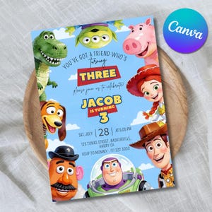May include: A rectangular birthday invitation card featuring cartoon characters including a green dinosaur, a three-eyed alien, a pink pig, a cowgirl, a dog, a potato figure, and a space ranger. The text reads: You've got a friend who's turning three, Jacob is turning 3, Sat, July 28 at 5:00 PM, 123 Tunas Street, Baskerville, Harry CA, RSVP to Mommy: 111 222 3330.