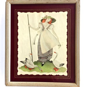 May include: Framed vintage print featuring a woman in a white dress and green hat, holding a staff, with three geese. The artwork has a scalloped edge, a burgundy mat, and a gold frame. The illustration has a vintage aesthetic.