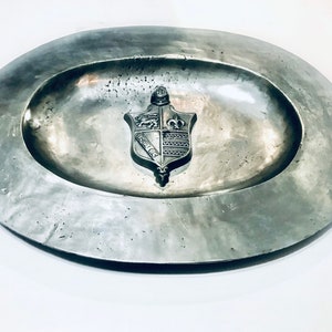 May include: A white ceramic mug with a black handle and the text "But First, Coffee" in a handwritten style. The mug is on a white surface. The mug is approximately 4 inches tall.