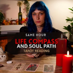 May include: A person with blue hair sits at a wooden table with three tarot cards and two red pillar candles. The text reads: SAME HOUR LIFE COMPASS AND SOUL PATH TAROT READING. The person wears a black top and holds a deck of tarot cards.