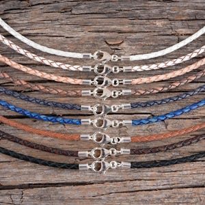 A front top view of braided leather necklaces displayed on a rustic wood background.