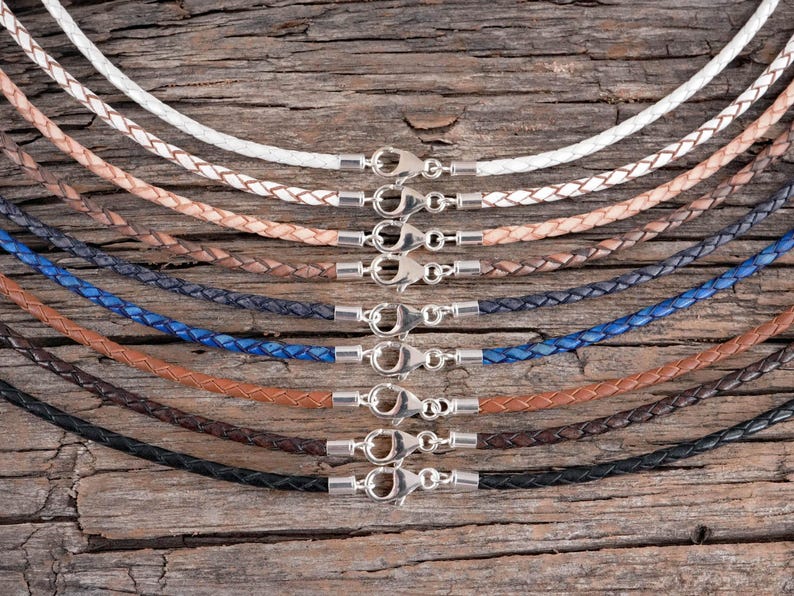 A front top view of braided leather necklaces displayed on a rustic wood background.