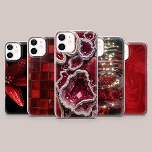 May include: Five smartphone cases arranged in a row, each featuring a distinct red design: a red flower with water droplets, a red grid pattern, a red geode crystal texture, a red water ripple effect with light reflections, and a red marble swirl.