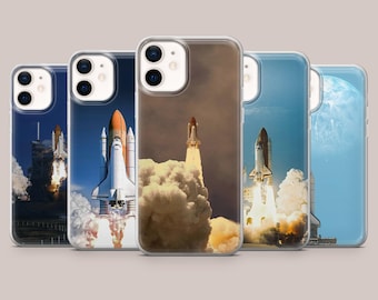 May include: A collection of five smartphone cases featuring various photographic prints of space shuttles during launch sequences, with visible exhaust plumes, bright flames, and clear blue or dark sky backgrounds, each case showing a dual camera lens cutout.