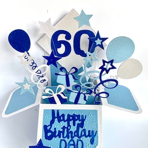 May include: A blue and white pop-up card with the number 60, stars, balloons, and presents. The card says "Happy Birthday Dad" inside.