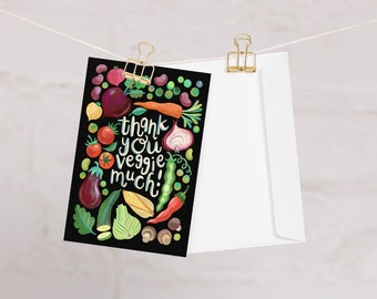 May include: A black card with a colorful illustration of various vegetables and the text "Thank you veggie much!" on a white background.