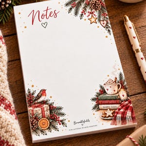 May include: A rectangular notepad with white paper featuring the red script word Notes at the top. The border is decorated with illustrations of pine branches, red berries, a robin, gifts, a mug of cocoa, books, and stars on a white background.