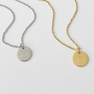 May include: Two delicate necklaces with rainbow charm pendants. One necklace has a silver chain and pendant, the other has a gold chain and pendant.