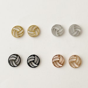 May include: Six pairs of volleyball earrings in gold, silver, black, and rose gold.
