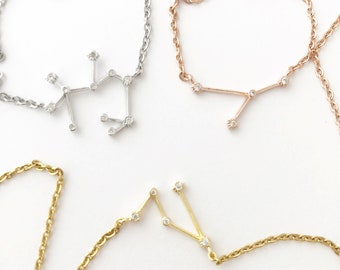May include: Three silver, gold, and rose gold necklaces with a constellation design. Each necklace features a constellation with small clear stones.